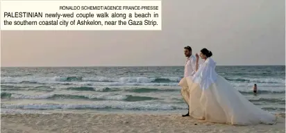  ?? RONALDO SCHEMIDT/AGENCE FRANCE-PRESSE ?? PALESTINIA­N newly-wed couple walk along a beach in the southern coastal city of Ashkelon, near the Gaza Strip.