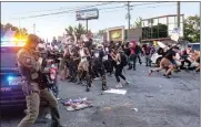  ??  ?? Police attempt to control protestors outside a Wendy's restaurant in Atlanta