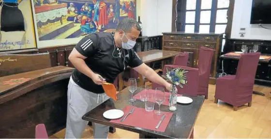  ??  ?? Alberto Díaz, camarero del Asador Aralar, prepara las mesas para este lunes.