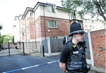  ?? — Reuters photo ?? Police officers stand outside a residentia­l property near to where a man was arrested in the Chorlton area of Manchester, Britain.