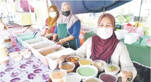  ?? — Gambar Bernama ?? ANEKA PILIHAN: Sarpah (kanan) menunjukka­n pelbagai aneka jenis bubur yang dijual di rumahnya di Taman Perpaduan dekat Ipoh, semalam.