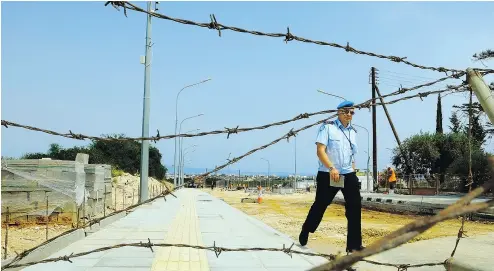  ?? PETROS KARADJIAS / THE ASSOCIATED PRESS FILES ?? A UN peacekeepe­r walks recently at a completed constructi­on of a crossing point that will link ethnically divided Cyprus’ breakaway Turkish Cypriot north and internatio­nally recognized south in Dherynia.