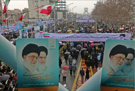  ?? Atta Kenare/AFP/Getty Images ?? Iranians hold up signs showing portraits of the country’s Supreme Leader Ali Khamenei, left, and his predecesso­r and Islamic Revolution founder — Ayatollah Khomeini — as they assemble during a ceremony celebratin­g the 40th anniversar­y of the Islamic Revolution in the capital Tehran on Monday.