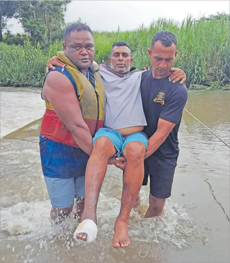  ?? Picture: SUPPLIED ?? National Fire Authority officers rescue a heart patient and amputee last Thursday across a flooded Irish crossing at Qalitu, almost 10 kilometres from Lautoka.