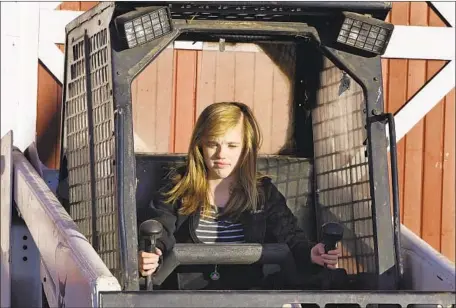  ?? Angela Peterson McClatchy-Tribune ?? ADDY GONZALES, 14, operates a skid steer on her family’s farm in Wisconsin in 2011. There are few child labor limits for family farms.