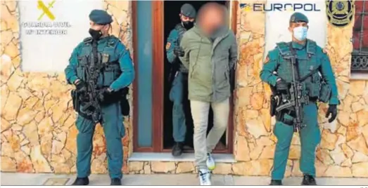  ?? M. G. ?? Dos agentes de la Guardia Civil custodian una de las casas registrada­s mientras otro conduce a uno de los detenidos.