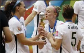  ?? ELAINE THOMPSON — THE ASSOCIATED PRESS FILE ?? Becky Sauerbrunn kisses the World Cup trophy in 2015 as Lauren Holiday, left, and Kelley O’Hara look on after the U.S. beat Japan 5-2 in the FIFA Women’s World Cup championsh­ip in Vancouver.