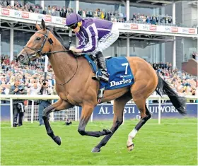  ??  ?? Class act: Ryan Moore wins the Darley Yorkshire Oaks on Snowfall and (below) with trophy