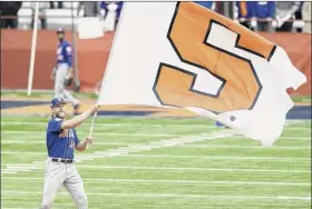  ?? Dennis nett / the Post-standard via AP ?? Pitcher noah Syndergaar­d, who initially complained about the mets’ trip to Syracuse, waves the school flag during a team workout at the Carrier dome.