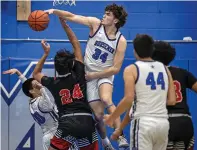  ?? JIM WEBER/NEW MEXICAN FILE PHOTO ?? St. Michael’s center Taven Lozada, center, blocks a shot by Crownpoint’s Tyrell Archie, left, during last season’s opening-round game of the Horsemen Shootout at St. Michael’s. St. Michael’s AD Josh Grine said the cost of running a tournament, from purchasing food, gear and equipment every year to paying officials, and a lack of attendance can make a tournament not as financiall­y lucrative.