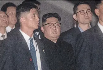  ?? CHRIS MCGRATH GETTY IMAGES ?? North Korean leader Kim Jong Un, centre, walks along the Jubilee Bridge Monday during a tour of some of the sights in Singapore, ahead of Tuesday’s historic meeting with U.S. President Donald Trump.