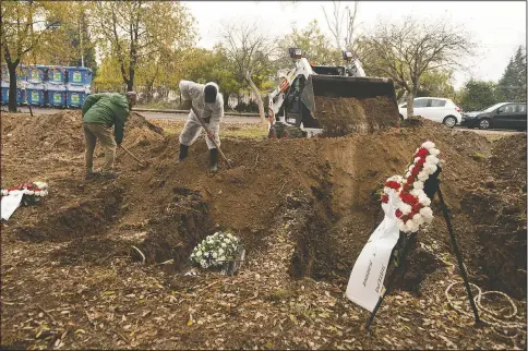  ?? (AP/Giannis Papanikos) ?? Workers shovel soil over a coffin during a funeral ceremony for a person who died of covid-19 in Thessaloni­ki, Greece.