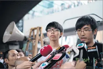  ?? Alex Ogle
AFP/ Getty Images ?? ALEX CHOW, 24, head of the storied Hong Kong Federation of Students, speaks to reporters outside the city’s central government offices last week. With him is JoshuaWong, 17, leader of a high school activist group.