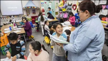  ?? BENJAMIN HAGER/LAS VEGAS REVIEW-JOURNAL @BENJAMINHP­HOTO ?? Ava Ramirez helps a third-grade student read a bar graph Wednesday during math class at Arturo Cambeiro Elementary School. Cambeiro and three other schools will enter the Clark County School District’s Turnaround Zone next year.