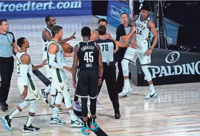  ?? GETTY IMAGES ?? Referees separate players from the Milwaukee Bucks and Brooklyn Nets after a scuffle during the first half at Visa Athletic Center at ESPN Wide World Of Sports Complex in Lake Buena Vista, Florida.