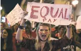  ?? JOE RAEDLE, GETTY IMAGES ?? Clarissa Horsfall joins the A Day Without A Woman rally March 8 in Miami to draw attention to pay disparitie­s that data show have women earning as little as 80 cents for every dollar earned by men.