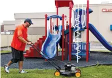  ?? STAFF PHOTO BY DOUG STRICKLAND ?? Head of school Josh Yother mows the grass around the playground Thursday at Skyuka Hall's new location.