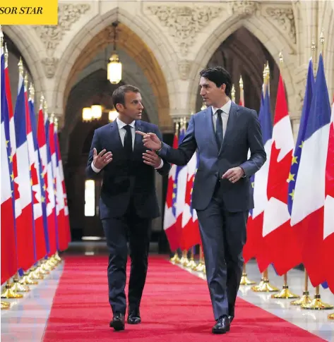  ?? PATRICK DOYLE/THE CANADIAN PRESS ?? Prime Minister Justin Trudeau and French President Emmanuel Macron walk down the Hall of Honour on Parliament Hill on Thursday.