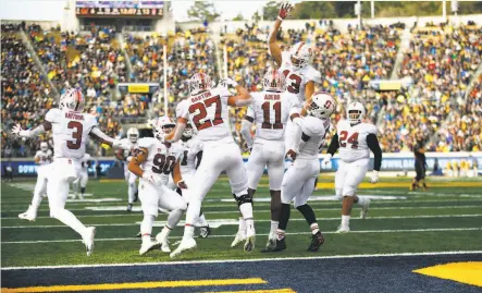  ?? Photos by Santiago Mejia / The Chronicle ?? Stanford teammates swarm freshman Paulson Adebo after one of his two intercepti­ons Saturday afternoon in Berkeley.