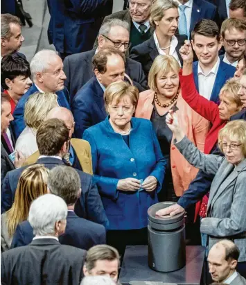  ?? Foto: Michael Kappeler, dpa ?? In diesem Fall ist Bundeskanz­lerin Angela Merkel eine Abgeordnet­e wie all die anderen um sie herum: Sie muss warten, bis die namentlich­e Abstimmung im Bundestag eröffnet ist und sie ihre Stimmkarte einwerfen kann.