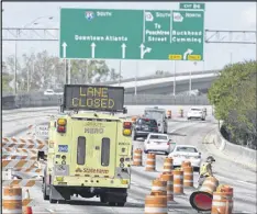  ?? DAVID BARNES / DAVID.BARNES@AJC.COM ?? Signs directing traffic off of I-85 Southbound in Atlanta on Friday. Many companies were encouragin­g workers to telecommut­e or use MARTA in the wake of the I-85 fire and collapse.