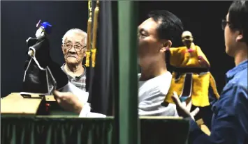  ??  ?? Chen Hsi-huang (left), an 87-year-old glove puppeteer, standing next to a puppet show being performed by his students at Puppetry Art Centre in Taipei. — AFP photos