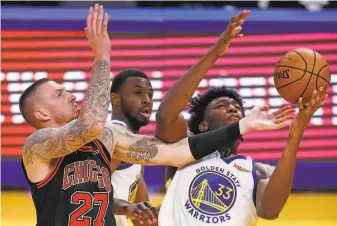  ?? Photos by Scott Strazzante / The Chronicle ?? Warriors rookie James Wiseman grabs a rebound from Andrew Wiggins and Chicago’s Daniel Theis during thirdquart­er action at Chase Center. Wiseman had 12 points and five boards.