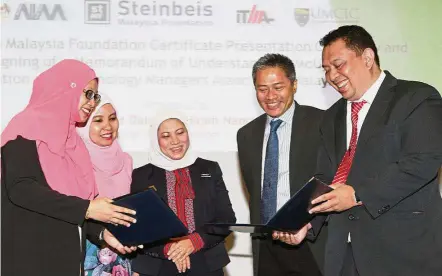  ??  ?? Working together: ITMA president and associate professor Dr. Samsilah Roslan (far left) exchanging the MoU document with Abdul Reezal (far right), witnessed by (from left) UM associate professor Dr. Sumiani Yusoff, Nancy and Rozario.