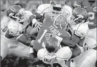  ?? Arkansas Democrat-Gazette/BENJAMIN KRAIN ?? Several Arkansas defenders take down Florida quarterbac­k Tim Tebow (center) during their game on Oct. 17, 2009. Tebow was sacked 6 times, but he accounted for 324 yards of total offense and 1 passing touchdown in the Gators’ 23-20 victory.