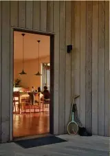  ??  ?? Right and facing page Emma Morris and partner Tom Locke at the dining table with Hazel, Wilson, Maurice and Kaya. The kitchen opens onto the front deck, which runs the length of the house. The ‘Beat’ pendant lights are by Tom Dixon and the ‘No.210r’...