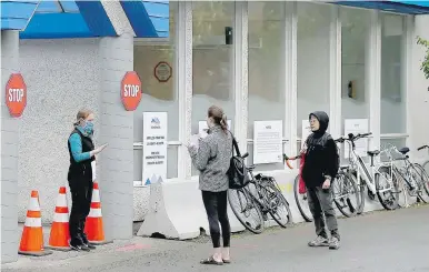  ?? ADRIAN LAM, TIMES COLONIST ?? People wait outside the James Bay Urgent and Primary Care Centre at the James Bay Community Project, 547 Michigan St., on opening day on April 28.