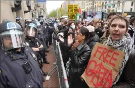  ?? MARY ALTAFFER — THE ASSOCIATED PRESS FILE ?? Police in riot gear stand guard as demonstrat­ors chant slogans outside the Columbia University campus in New York on Thursday.