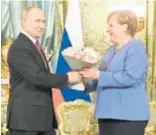  ?? AFP ?? Putin recibió con flores a Merkel