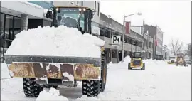 ?? Tony Dejak Associated Press ?? STREETS ARE CLEARED in Erie, Pa., where 65 inches of snow have fallen since Christmas Eve. New Year’s Eve celebratio­ns in several states are being canceled.