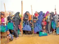  ??  ?? Rohingya women with their children stand in a queue outside a food distributi­on centre at the Balukhali camp in Bangladesh. —