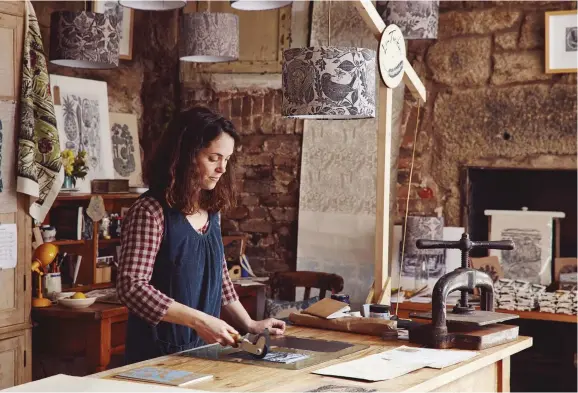  ??  ?? CLOCKWISE FROM TOP Formerly the village bus store, Lou’s stone studio provides a calm space for her work; she applies light pressure to paper placed over inked lino; a notepad imprinted with a monochrome blue tit; a view of the breezy Cornish coast from an artfully cluttered window