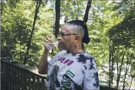  ?? Leah Willingham Associated Press ?? DONNA DICKERSON drinks tap water on the porch of her trailer in Keystone, W.Va. The community was finally hooked up to a new water system last year.