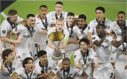  ?? Picture: AFP ?? SILVERWARE AT LAST. Eintracht Frankfurt captain Sebastian Rode holds the trophy surrounded by teammates after winning the Europa League at the Ramon Sanchez Pizjuan Stadium on Wednesday.