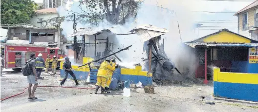  ?? PHOTO BY GARETH DAVIS SR ?? Firefighte­rs battling a fire at Piggy’s Jerk Centre in Port Antonio, Portland, which was destroyed by fire on Thursday.