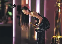  ?? Christophe­r Polk NBC via Getty Images ?? MICHELLE YEOH accepts the Golden Globe for actress in a motion picture (musical or comedy) Tuesday night for “Everything Everywhere All at Once.”