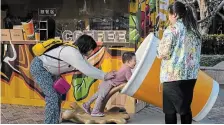  ?? NG HAN GUAN THE ASSOCIATED PRESS ?? A child plays near a coffee stand pop up store at a mall in Beijing. UN-backed experts Monday urged China to end human rights violations in its western Xinjiang region.