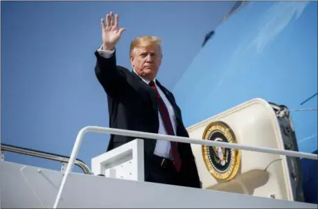  ??  ?? EVAN VUCCI — THE ASSOCIATED PRESS President Donald Trump waves as he boards Air Force One for a trip to New York to attend a fundraiser, Thursday at Andrews Air Force Base, Md.
