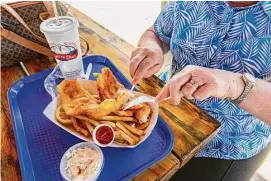  ?? Lisa Nichols/Hearst Connecticu­t Media file photo ?? A customer digs in to fish and chips at Captain's Scott's Lobster Dock in New London. Lenten fish fries take place through April 7 in Connecticu­t.