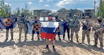  ?? ?? Yevgeny Prigozhin, the head of the Wagner Group military company, holds the Russian flag amid the rubble of Bakhmut, which Moscow claims to have fully captured.