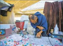  ?? ?? JOSE LUIS Camargo presses and starches clothing at his encampment beneath the 110 and 105 freeways in Los Angeles.