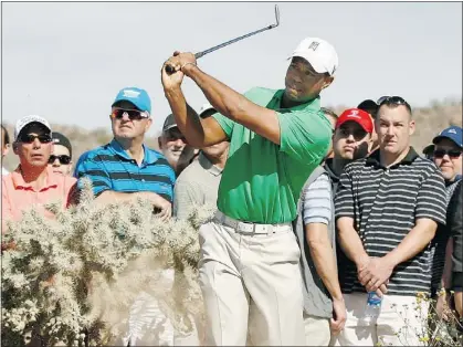  ?? — REUTERS ?? Tiger Woods hits left-handed out of the desert rough during Wednesday’s play.