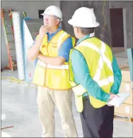  ?? Westside Eagle Observer/MIKE ECKELS ?? Bryce Landers (left) listens intently as Gentry Mayor Kevin Johnson inquires about the new Simmons poultry processing plant during a tour of the facility July 2.