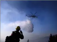  ?? NOAH BERGER — THE ASSOCIATED PRESS FILE ?? On Oct. 29, 2019, a helicopter drops water while battling the Kincade Fire near Healdsburg, Calif. As wildfire risks heat up, startups in California’s Silicon Valley are starting to take notice. One startup makes a fire retardant spray that is safe for plants and designed to keep fires from spreading.