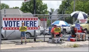  ?? The Sentinel-Record/Grace Brown ?? LAST-MINUTE CAMPAIGNIN­G: Representa­tives of various candidates campaign along Ouachita Avenue in front of the Garland County Election Commission Building on Tuesday.
