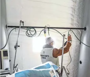  ?? STEPHANIE KEITH/GETTY IMAGES ?? A person sets up power and oxygen lines Monday in an emergency field hospital in Central Park to aid the response to the COVID-19 pandemic in New York City.